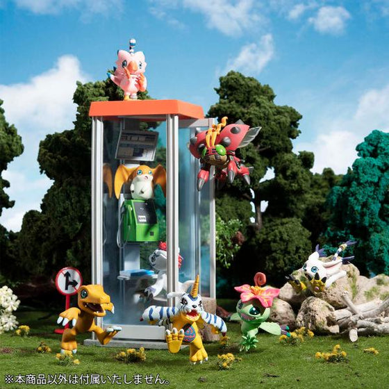 A collection of Digimon Adventure anime character figures in a garden setting, including the series' main characters and various other colorful figures.